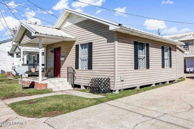 bungalow-style home featuring covered porch and metal roof