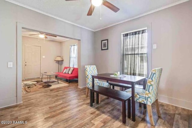 dining space with baseboards, ceiling fan, and wood finished floors