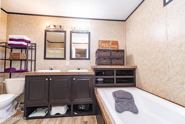 full bath with double vanity, toilet, crown molding, tile walls, and a washtub