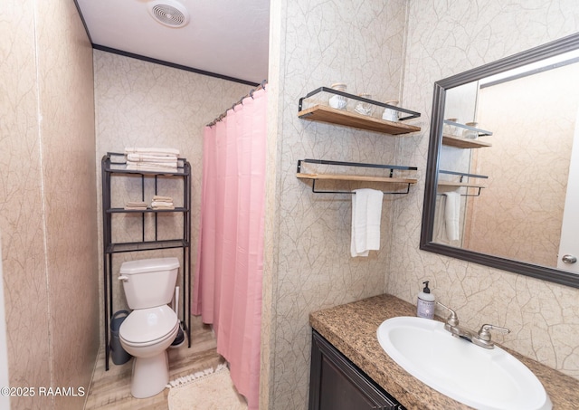 full bathroom featuring tile walls, toilet, visible vents, vanity, and crown molding