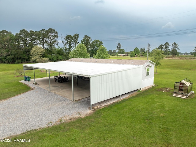 view of property exterior with a carport, a yard, and gravel driveway