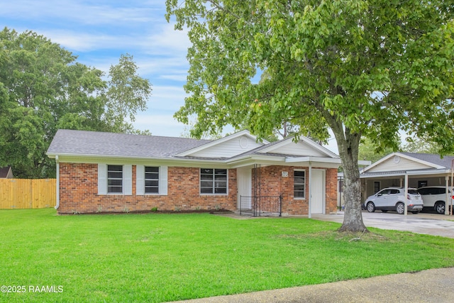 ranch-style home with fence, roof with shingles, a front lawn, brick siding, and concrete driveway