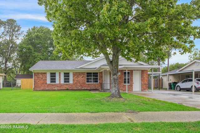 ranch-style house with brick siding, a front lawn, fence, and concrete driveway
