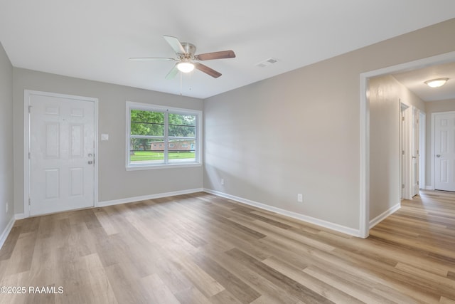 unfurnished room with a ceiling fan, baseboards, visible vents, and light wood-style floors