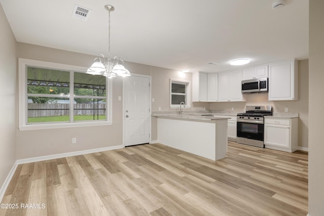 kitchen featuring visible vents, white cabinetry, light wood finished floors, and stainless steel appliances