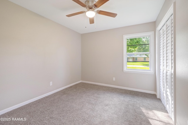 spare room featuring baseboards, a ceiling fan, and carpet flooring