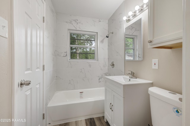 bathroom with toilet, shower / washtub combination, wood finished floors, and vanity