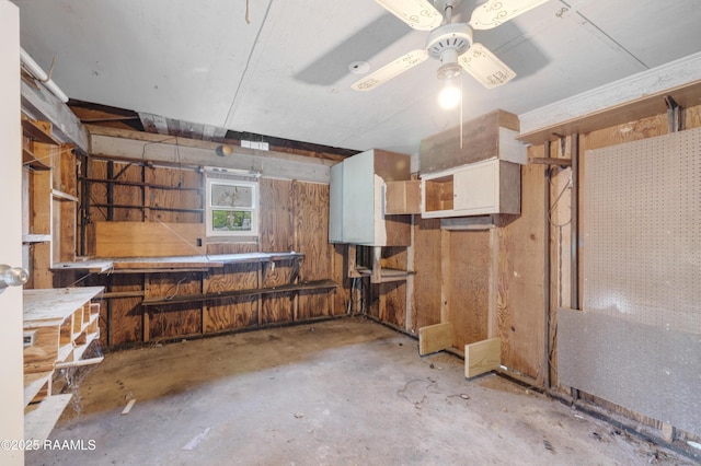 below grade area with ceiling fan and a workshop area