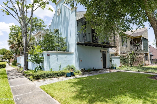 211 Ursuline St, Lafayette, LA 70506 - view of front of home featuring a balcony, a front lawn, and stucco siding