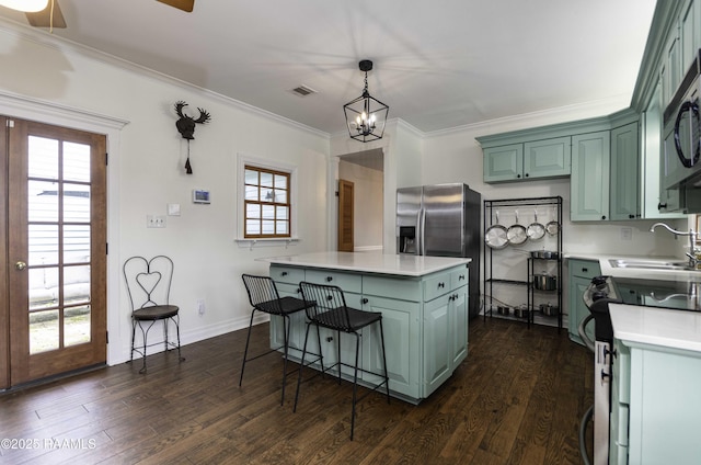 211 Ursuline St, Lafayette, LA 70506 - kitchen with green cabinetry, light countertops, ornamental molding, and healthy amount of natural light