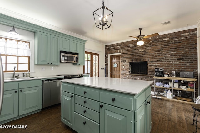 211 Ursuline St, Lafayette, LA 70506 - kitchen with green cabinetry, appliances with stainless steel finishes, ceiling fan, dark wood-style floors, and brick wall
