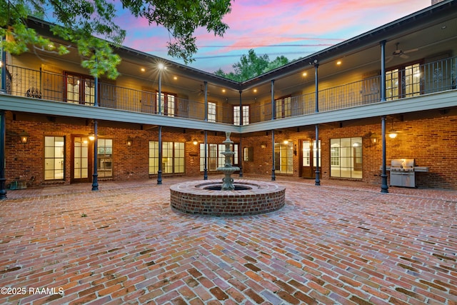 110 Interlaken Dr, New Iberia, LA 70563 - back of property at dusk with a balcony, ceiling fan, and brick siding