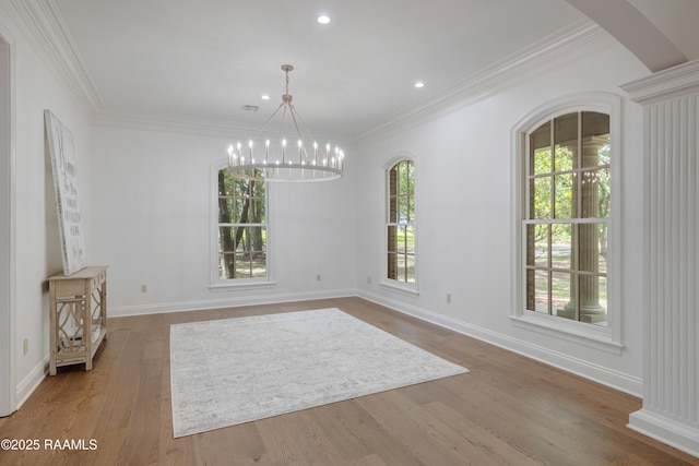 110 Interlaken Dr, New Iberia, LA 70563 - unfurnished dining area featuring a chandelier, wood finished floors, crown molding, arched walkways, and baseboards