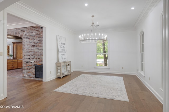 110 Interlaken Dr, New Iberia, LA 70563 - unfurnished dining area featuring a chandelier, wood finished floors, baseboards, crown molding, and arched walkways