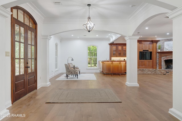 110 Interlaken Dr, New Iberia, LA 70563 - entryway featuring ornate columns, light wood-style flooring, arched walkways, french doors, and crown molding