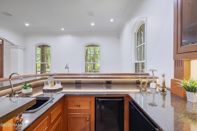 110 Interlaken Dr, New Iberia, LA 70563 - kitchen featuring brown cabinetry, crown molding, healthy amount of natural light, a sink, and glass insert cabinets