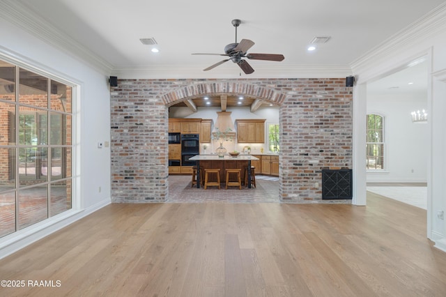 110 Interlaken Dr, New Iberia, LA 70563 - unfurnished living room featuring light wood-style floors, a ceiling fan, crown molding, a fireplace, and brick wall