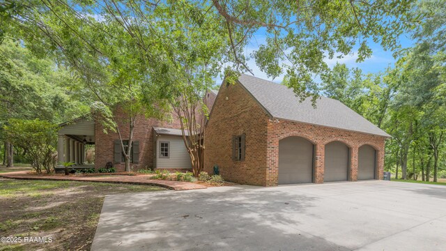 110 Interlaken Dr, New Iberia, LA 70563 - view of front facade with brick siding, driveway, a shingled roof, and a garage