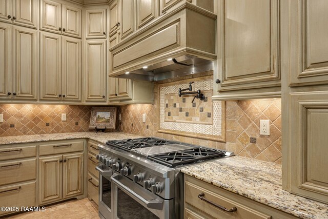 kitchen featuring premium range hood, cream cabinets, and double oven range