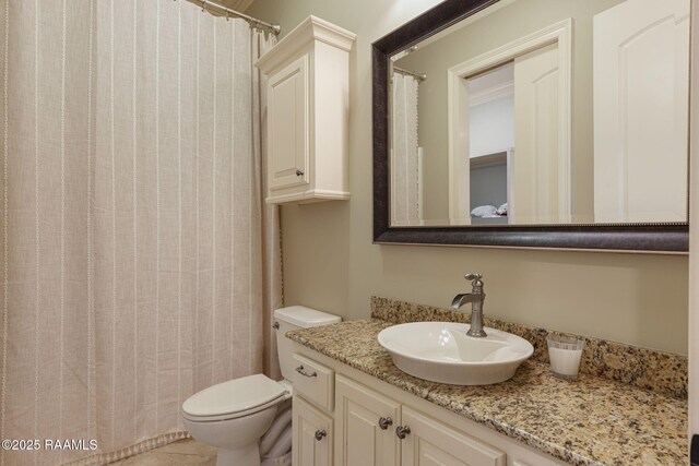 bathroom featuring vanity, tile patterned flooring, and toilet