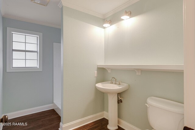 bathroom featuring toilet, baseboards, ornamental molding, and wood finished floors