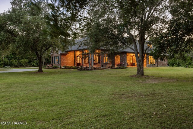 view of front of house featuring brick siding and a front yard