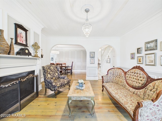544 E Main St, New Iberia, LA 70560 - living room featuring arched walkways, ornamental molding, a fireplace, hardwood / wood-style flooring, and a chandelier