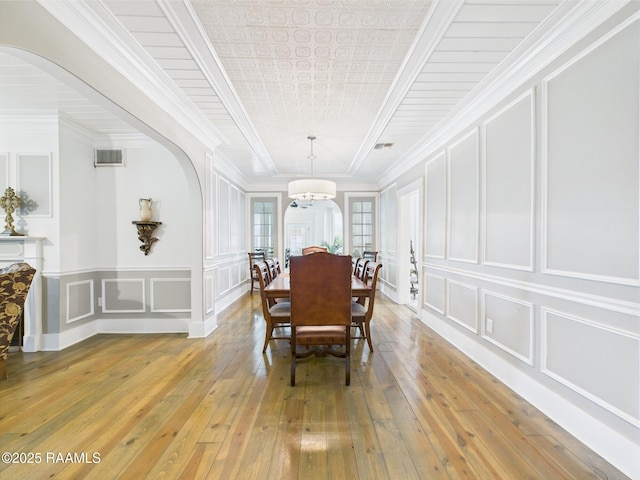 544 E Main St, New Iberia, LA 70560 - dining space with a decorative wall, arched walkways, light wood-style flooring, and ornamental molding
