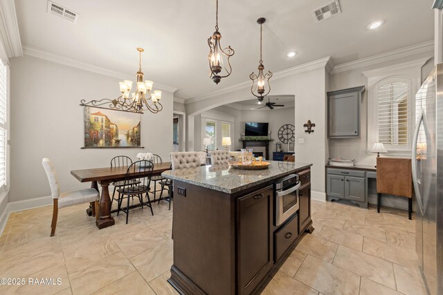kitchen featuring ceiling fan with notable chandelier, appliances with stainless steel finishes, visible vents, and a fireplace