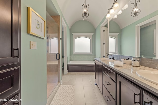 bathroom with a sink, double vanity, a shower stall, and a bath
