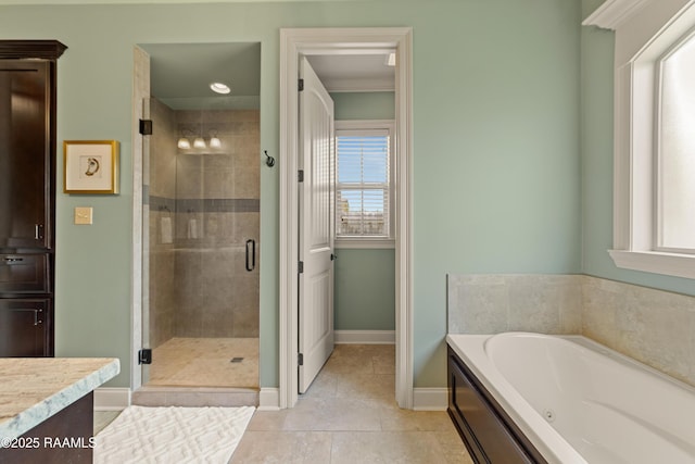 full bath with a garden tub, a shower stall, vanity, baseboards, and tile patterned floors