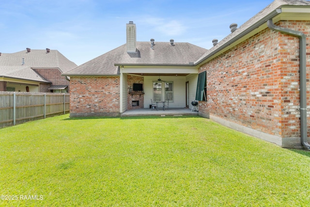 back of property with fence, a chimney, a patio area, and brick siding