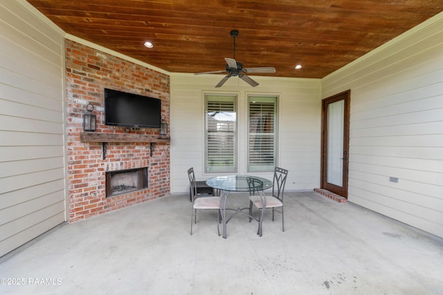 view of patio / terrace with a ceiling fan, outdoor dining space, and an outdoor brick fireplace