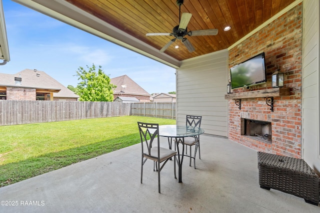 view of patio / terrace with ceiling fan, outdoor dining area, a fenced backyard, and an outdoor brick fireplace