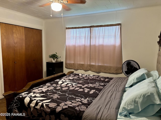 bedroom featuring crown molding, a ceiling fan, and a closet