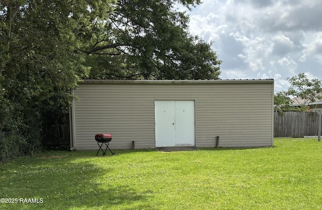 view of outdoor structure featuring fence and an outdoor structure