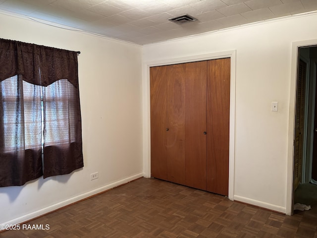 unfurnished bedroom featuring baseboards, visible vents, and a closet