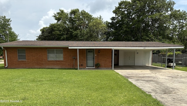 single story home featuring fence, a front yard, an attached carport, brick siding, and driveway
