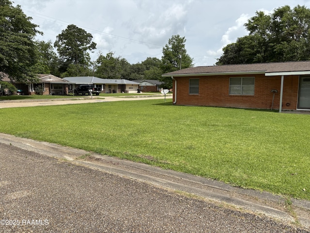 exterior space with a lawn, brick siding, and driveway