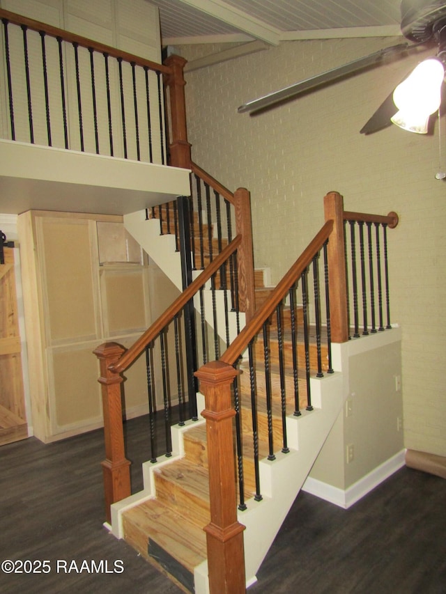 stairway featuring baseboards, ceiling fan, wood finished floors, and beamed ceiling