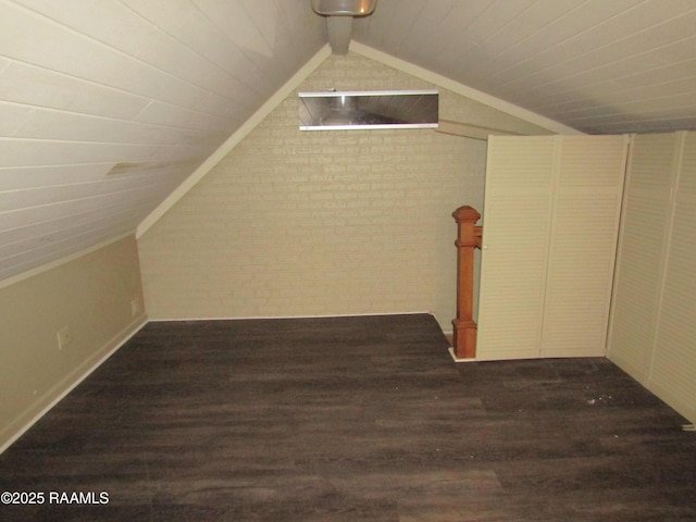 bonus room featuring brick wall, vaulted ceiling, and wood finished floors