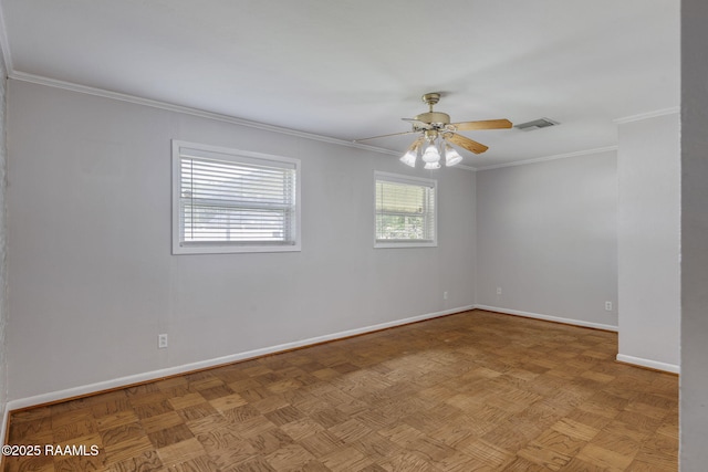 empty room featuring baseboards, ornamental molding, ceiling fan, and visible vents