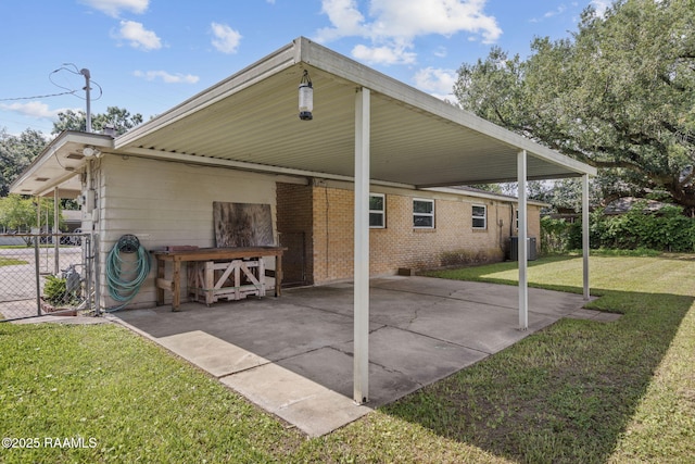 back of house featuring fence, an attached carport, a patio area, central air condition unit, and a yard