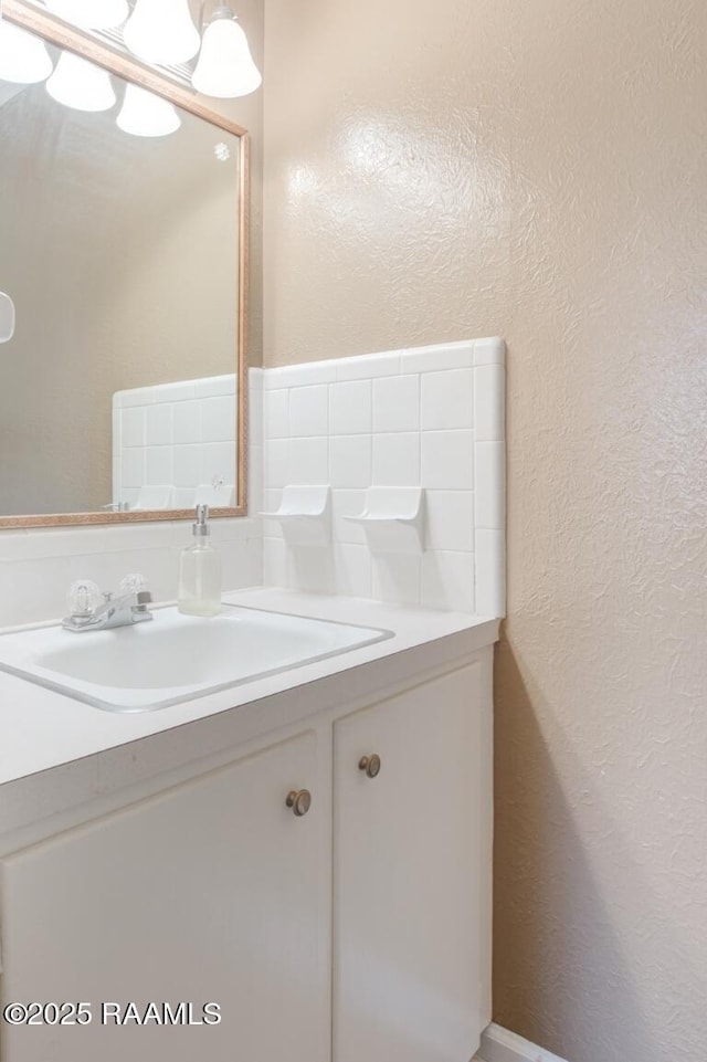 bathroom with a textured wall and vanity