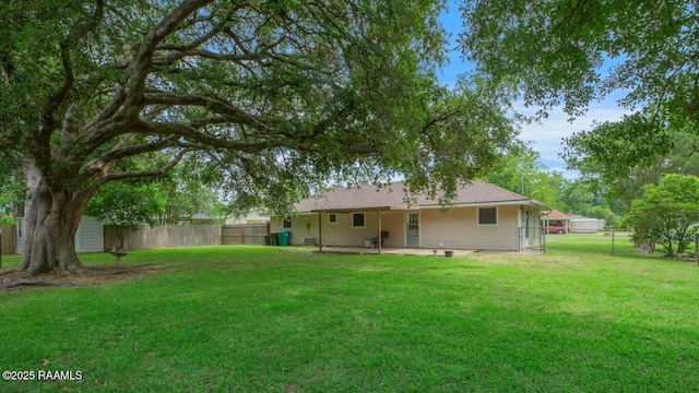 back of house with a patio, a fenced backyard, and a lawn