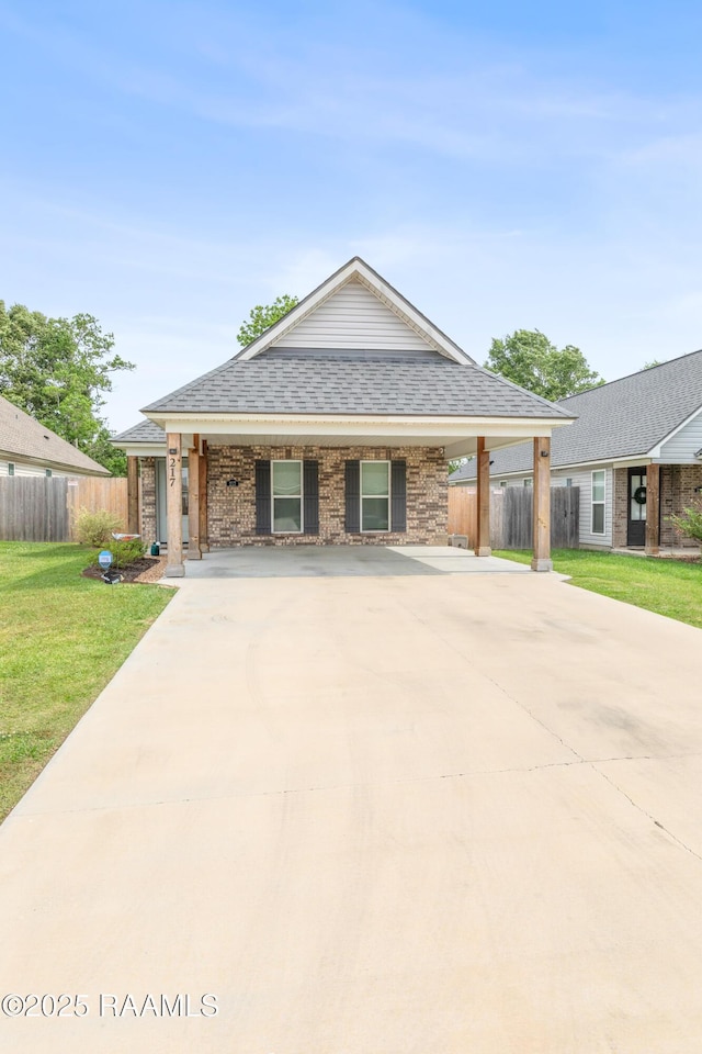 view of front of house featuring fence, driveway, and a front lawn