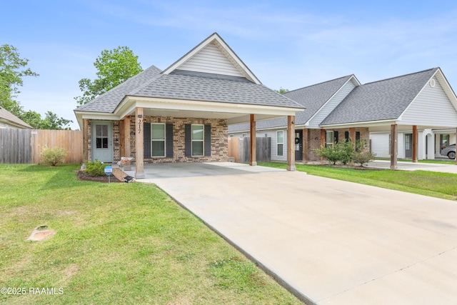 view of front of home featuring fence, a front yard, roof with shingles, brick siding, and driveway
