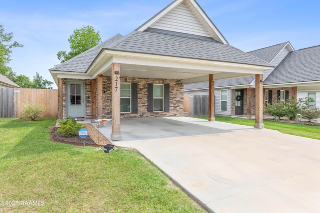 view of front of home featuring fence, roof with shingles, a front lawn, and brick siding