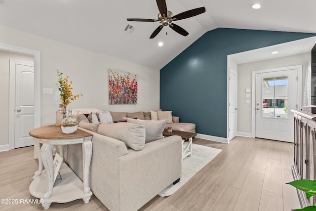 living room with visible vents, light wood-style floors, baseboards, a ceiling fan, and vaulted ceiling