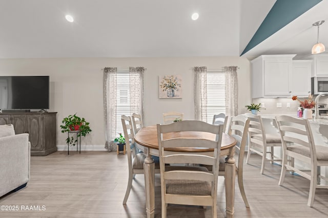 dining room featuring light wood-style floors, recessed lighting, baseboards, and vaulted ceiling